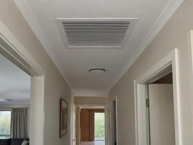 Hallway ceiling return-air grille in a painted home interior in Reedy Creek